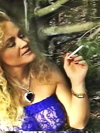 Cute MILF smokes a cigarette outdoors with...