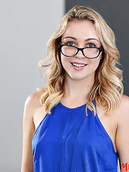 Blonde teen in blue overalls wears glasses that make her look ev