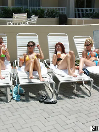 Bikini-clad babes pose next to the pool and masturbate together