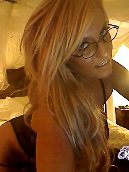 Busty babe Ember Reigns strips her black lingerie and teases in