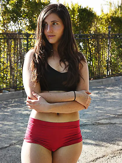 Fit brunette in red shorts gets nude outdoors