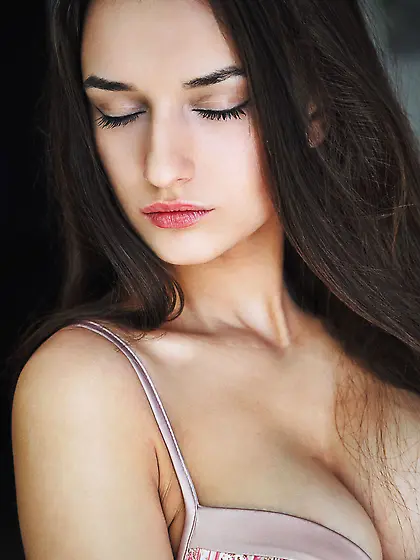 Leggy dark-haired chick flashes her smooth pussy on a big bed Vi