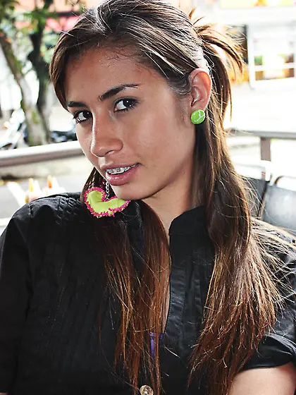 Brown eyed teen stripteasing