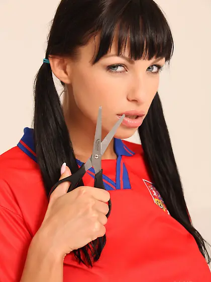 Pigtailed brunette posing seductively with scissors and a soccer