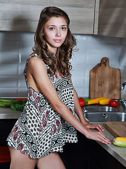 Dress-wearing brunette sucking on stuff in the kitchen before ge