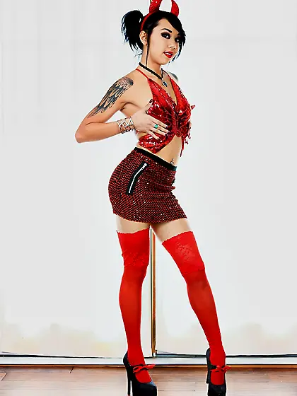 Sultry Eastern girl in a red Devil suit exposes her tattooed bod