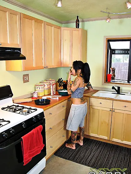 Tattooed brunette babe Capri Cavalli strips in the kitchen and s