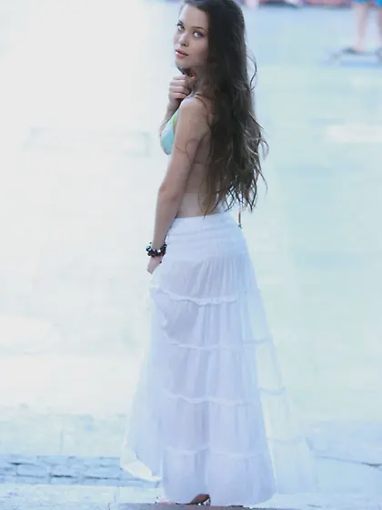 Dark-haired vixen shows her shapely breasts while posing indoors