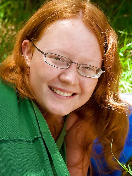 Redheaded seductress with a chubby bum is going to tease outside