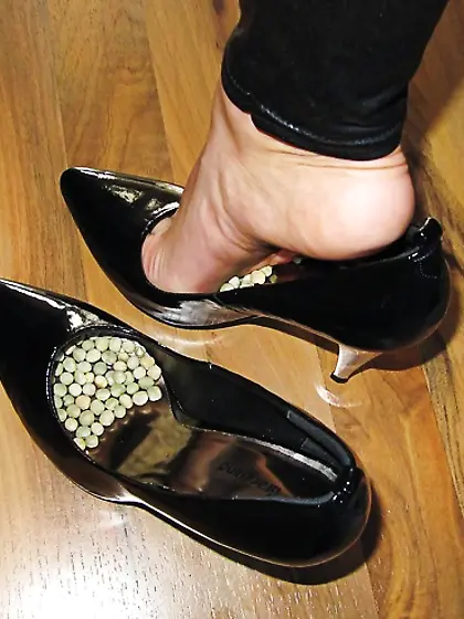 Foot torture with peas in high heels,  leggings and corset