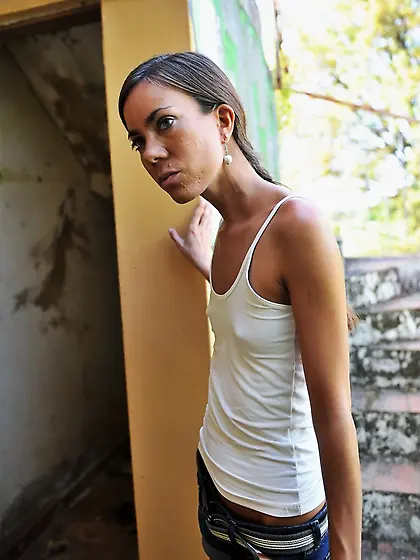 Skinny lassie spreads legs revealing trimmed pussy in the abando