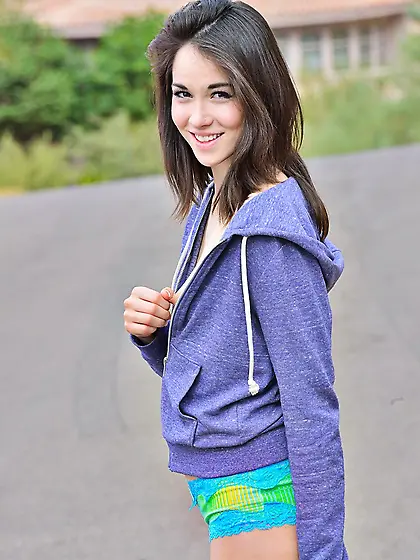 Smiling brunette teen Emily Grey is in the street uncovering vie