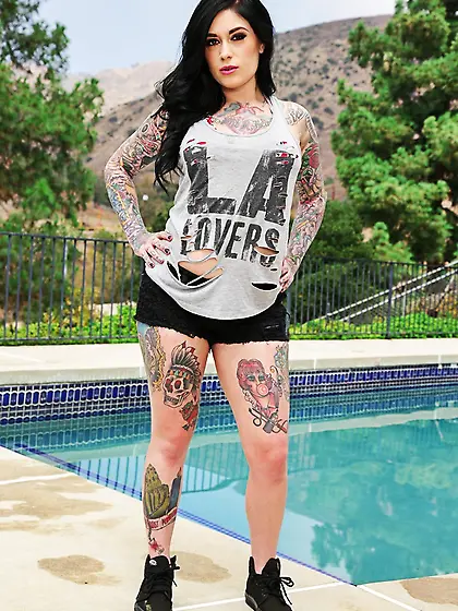 Inked brunette babe poses