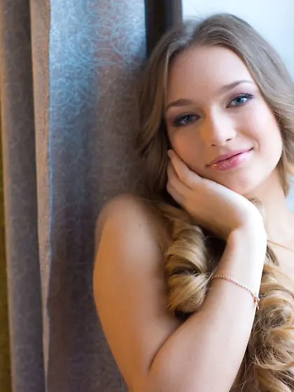 Curvy long-haired girl posing naked at the...