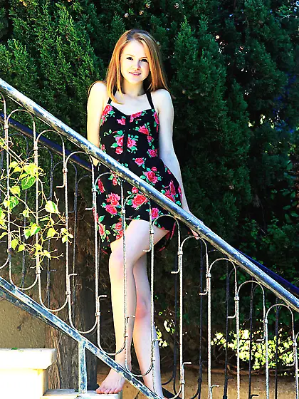 Teen redhead starts taking dress off on the stairs and poses nud
