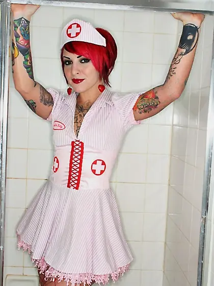 Nurse with red hair and meaningful tattoos over her body touches