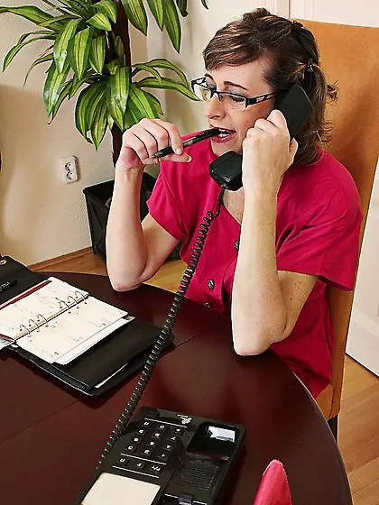 Slim mature secretary Judy Karups in pink shoes demonstrates her