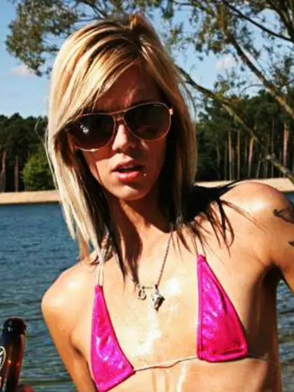 Oiled-up,  flat-chested blonde on beach