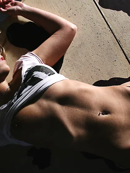 Young woman is lying on piano with spread legs while man is span