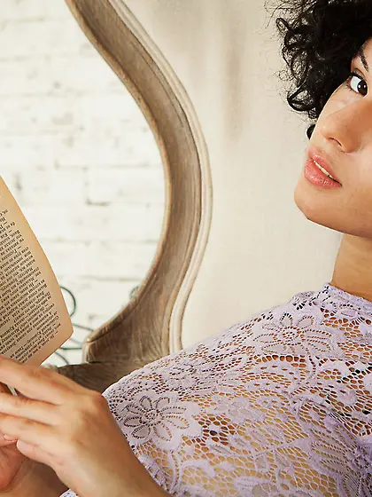 Curly-haired avid book reader decides to undress in a sun-lit ro