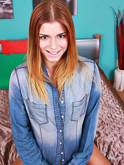 Denim-wearing redheaded teen fingering her juicy little pussy on