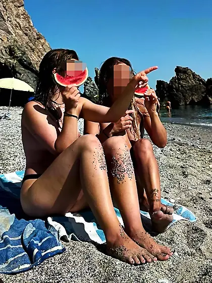 LMK and friend sitting on beach,  topless nip slip