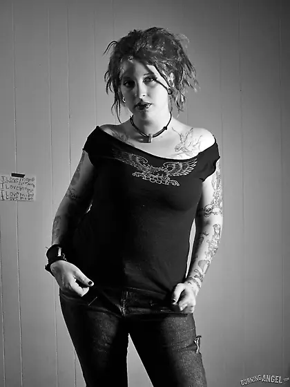 Chick with fuzzy hair reads a magazine and masturbates in black