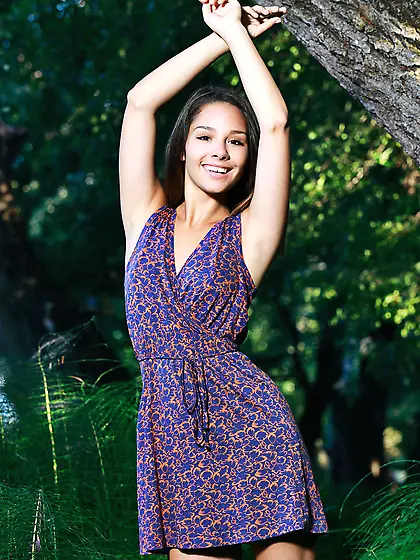 Wonderful teen model takes off her dress to pose naked in the wo