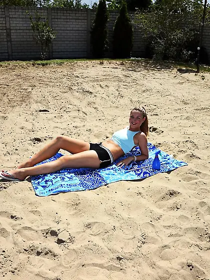 Blonde babe Angel Snow is lying on the beach uncovering the view