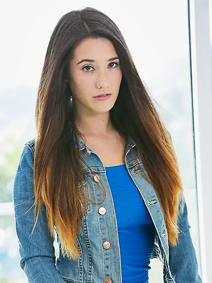 Frolicsome beauty Eva Lovia sits on chair in pose that accentuat