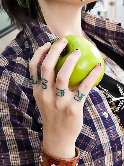 Tattooed coed with green locks eats an apple and fingers vagina