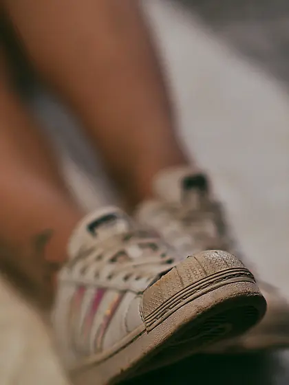 Feet in hot nylon and white Addidas sneakers