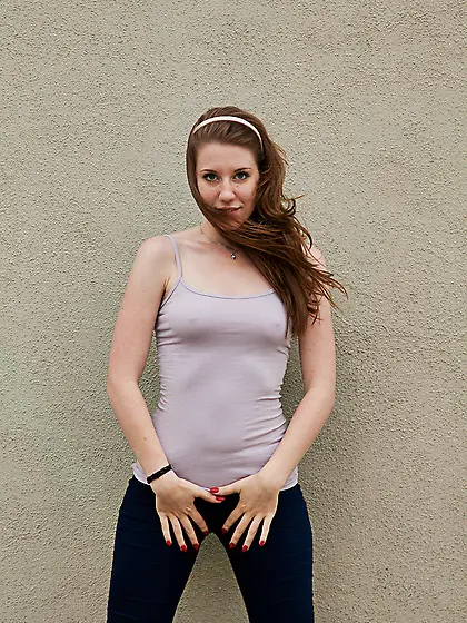 Slim teen redhead in sexy skinny jeans outdoors