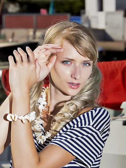 Angelic blonde in striped get-up posing with her legs spread on