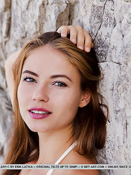 Winsome teen slips off sexy swim suit on the rocks near beautifu