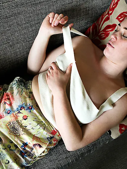 Comely beauty relaxes in living room with fingers inside her uns