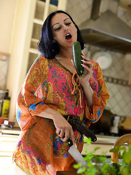 Short-haired brunette eagerly fucks her pussy with a large cucum