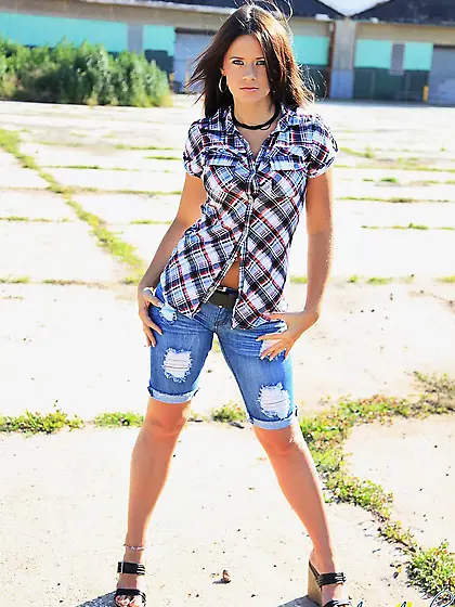 Petite clothed brunette Ann Angel with charming eyes poses in th