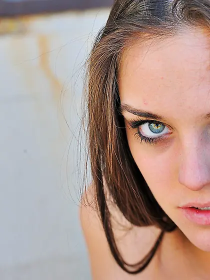 Black dress beauty with piercing blue eyes shows her smooth slit