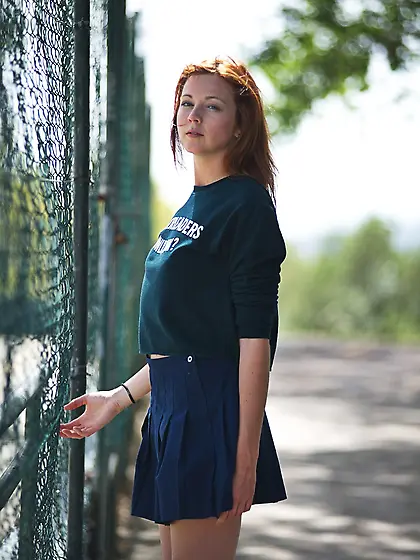 Hot red-haired cheerleader lifts skirt up to reveal panties and