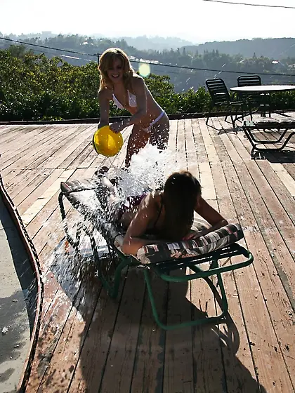 Ally Ann Tory Lane and Kandi Milan strip outdoors on the balcony