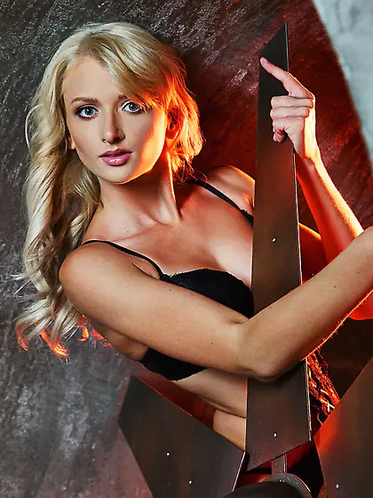 Blond-haired bombshell takes off her black lingerie next to a gi