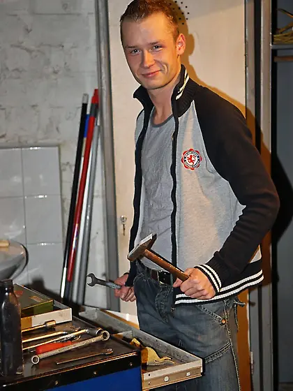 Young plumber opens jacket