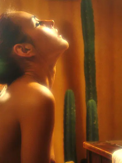 Ponytailed brunette posing in front of a mirror and stripping na