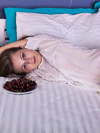 Young sexy brunette Ennu A is getting nude and rolling on the be