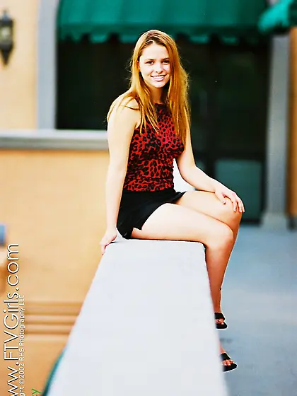 Cute blond babe,  Joey Lane posing in her red shirt and black ski