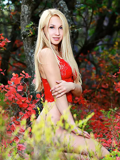 Blonde in red gets naked in the middle of a field of red flowers